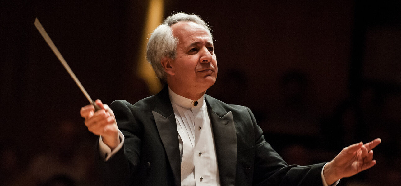 Foto do maestro Fabio Mechetti. Ele está com a batuta na mão e regendo um concerto.
